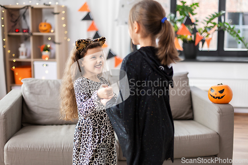 Image of girls in halloween costumes dancing at home