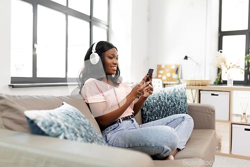 Image of woman with smartphone listening to music at home