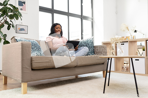 Image of african american woman with tablet pc at home