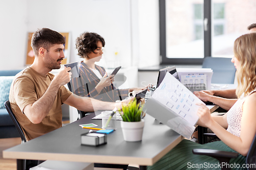 Image of team of startuppers drinking coffee at office