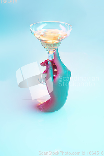 Image of Close up female hand gesturing from the milk bath with soft glowing in neon light