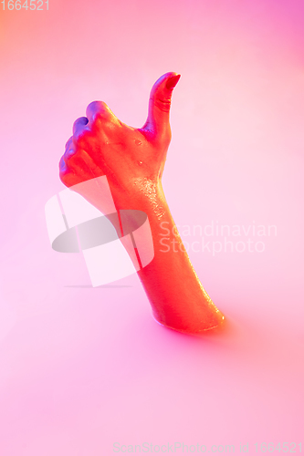 Image of Close up female hand gesturing from the milk bath with soft glowing in neon light