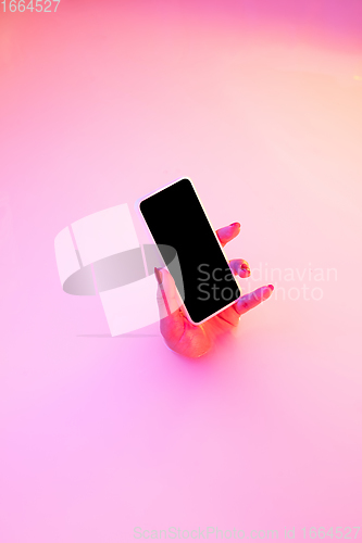 Image of Close up female hand gesturing from the milk bath with soft glowing in neon light