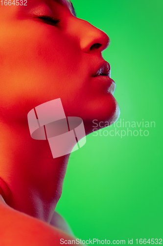 Image of Beautiful east woman close up portrait isolated on green background in red neon light