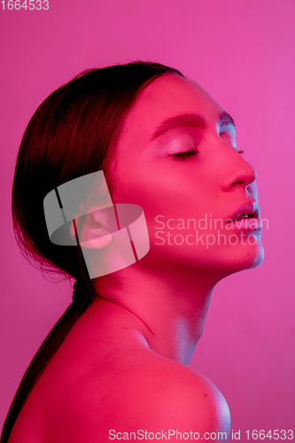 Image of Beautiful east woman portrait isolated on pink studio background in neon light, monochrome