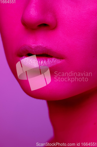 Image of Beautiful east woman portrait isolated on pink studio background in neon light, monochrome