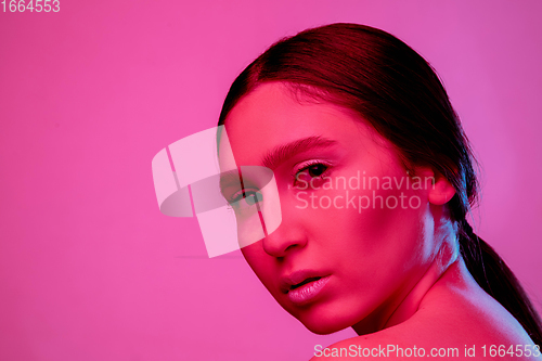 Image of Beautiful east woman portrait isolated on pink studio background in neon light, monochrome