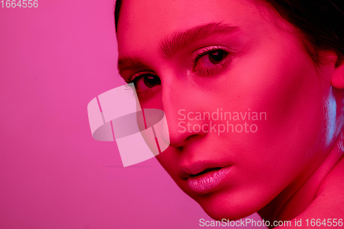 Image of Beautiful east woman portrait isolated on pink studio background in neon light, monochrome