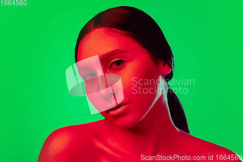 Image of Beautiful east woman close up portrait isolated on green background in red neon light