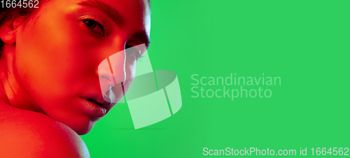 Image of Beautiful east woman close up portrait isolated on green background in red neon light