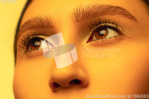 Image of Beautiful east woman close up portrait in golden colored neon light, monochrome