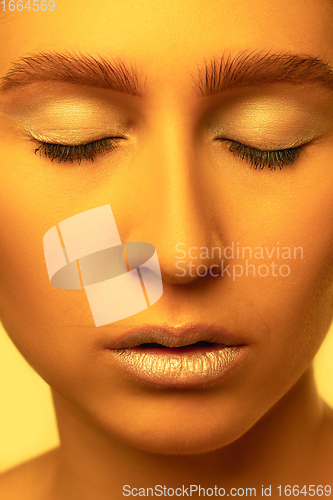 Image of Beautiful east woman portrait isolated on yellow studio background in neon light, monochrome