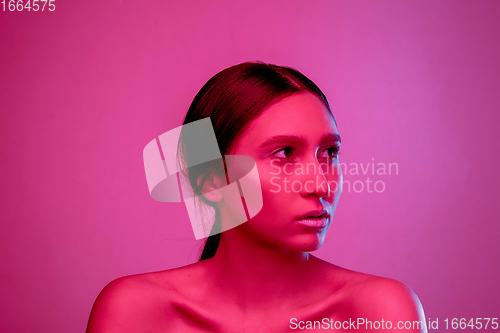 Image of Beautiful east woman portrait isolated on pink studio background in neon light, monochrome