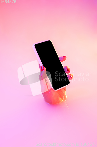 Image of Close up female hand gesturing from the milk bath with soft glowing in neon light