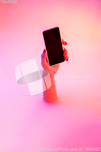 Image of Close up female hand gesturing from the milk bath with soft glowing in neon light