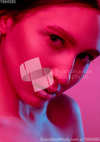 Image of Beautiful east woman portrait isolated on pink studio background in neon light, monochrome