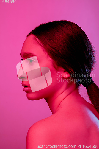 Image of Beautiful east woman portrait isolated on pink studio background in neon light, monochrome