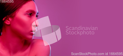 Image of Beautiful east woman portrait isolated on pink studio background in neon light, monochrome