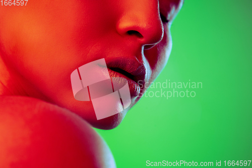 Image of Beautiful east woman close up portrait isolated on green background in red neon light