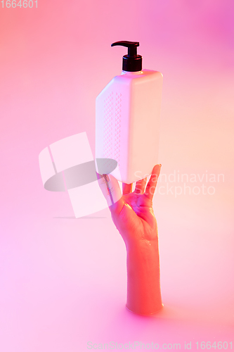 Image of Close up female hand gesturing from the milk bath with soft glowing in neon light