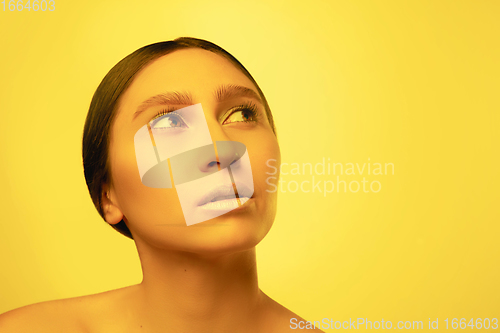 Image of Beautiful east woman portrait isolated on yellow studio background in neon light, monochrome