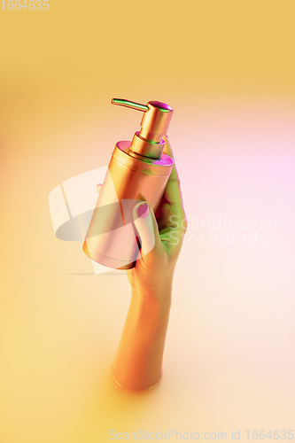 Image of Close up female hand gesturing from the milk bath with soft glowing in neon light