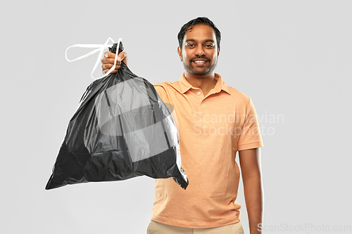 Image of smiling indian man holding trash bag