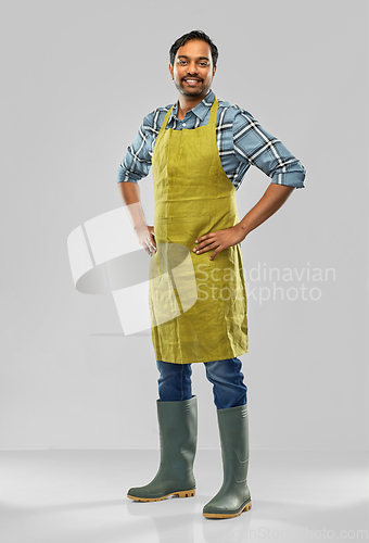 Image of happy indian male gardener or farmer in apron