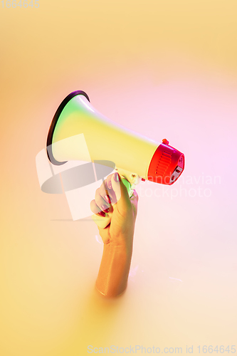 Image of Close up female hand gesturing from the milk bath with soft glowing in neon light