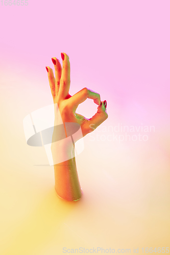 Image of Close up female hand gesturing from the milk bath with soft glowing in neon light