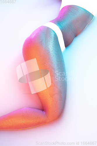 Image of Close up female body in the milk bath with soft glowing in neon light