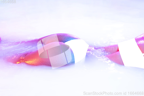 Image of Close up female body in the milk bath with soft glowing in neon light