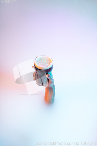 Image of Close up female hand gesturing from the milk bath with soft glowing in neon light