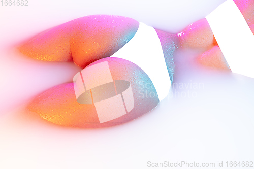 Image of Close up female body in the milk bath with soft glowing in neon light