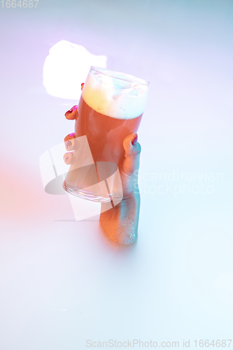 Image of Close up female hand gesturing from the milk bath with soft glowing in neon light