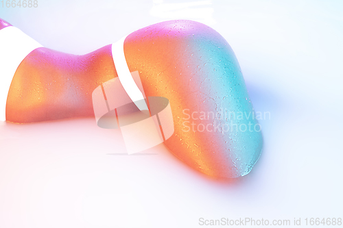 Image of Close up female body in the milk bath with soft glowing in neon light