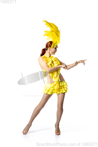 Image of Beautiful young woman in carnival, stylish masquerade costume with feathers dancing on white studio background.