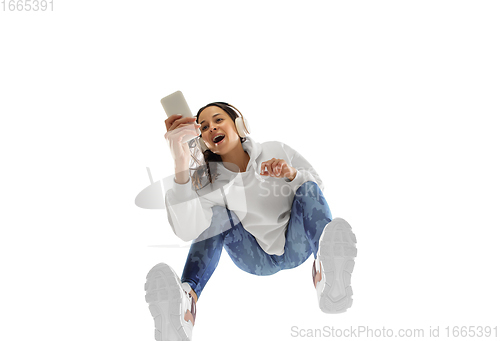 Image of Young stylish woman in modern street style outfit isolated on white background, shot from the bottom