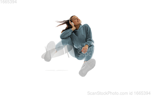Image of Young stylish woman in modern street style outfit isolated on white background, shot from the bottom