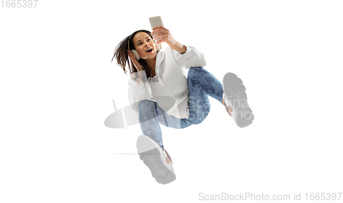 Image of Young stylish woman in modern street style outfit isolated on white background, shot from the bottom