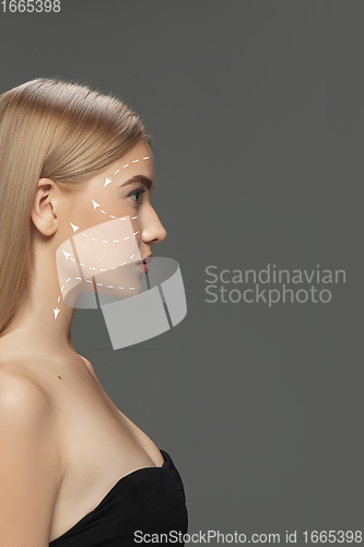 Image of Beautiful female face with lifting up arrows isolated on grey background