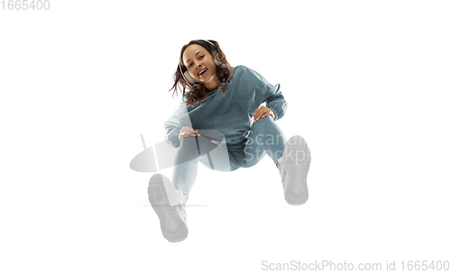 Image of Young stylish woman in modern street style outfit isolated on white background, shot from the bottom