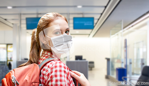 Image of young woman in mask with backpack at airport