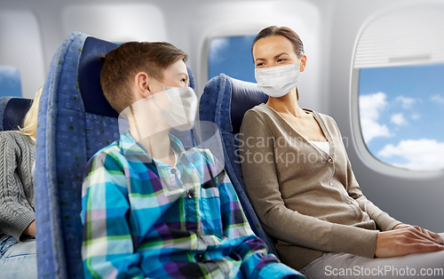 Image of mother and son in masks traveling by plane
