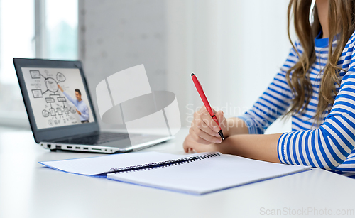 Image of student girl with exercise book, pen and laptop