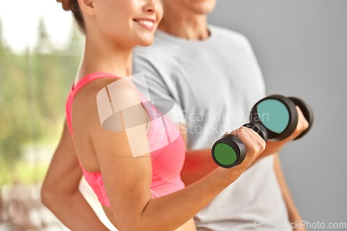 Image of close up of smiling woman with dumbbell in gym