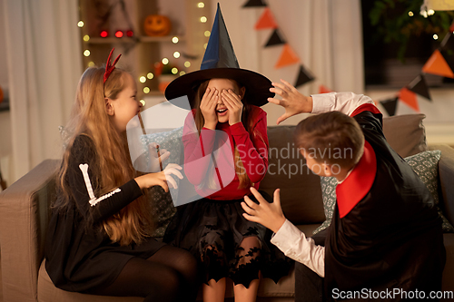 Image of kids in halloween costumes playing at home