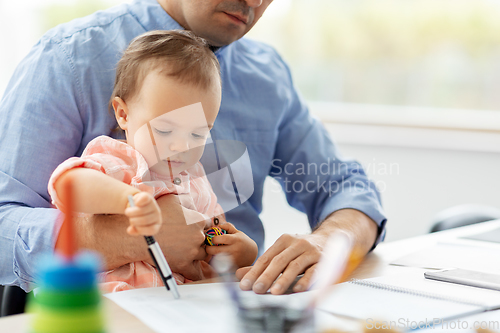 Image of father with baby working at home office