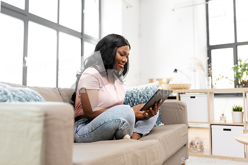 Image of african american woman with tablet pc at home