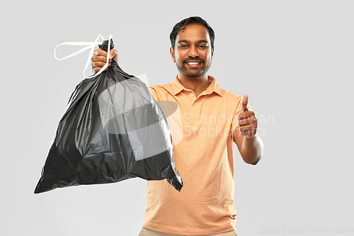 Image of happy indian man with trash bag showing thumbs up